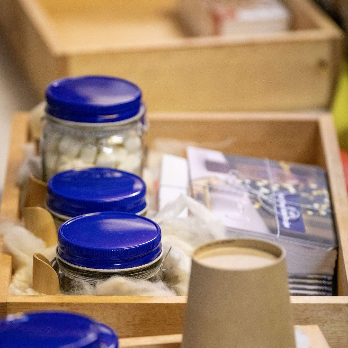 Close up of a wooden box with blue lidded mason jars and printed recipe cards