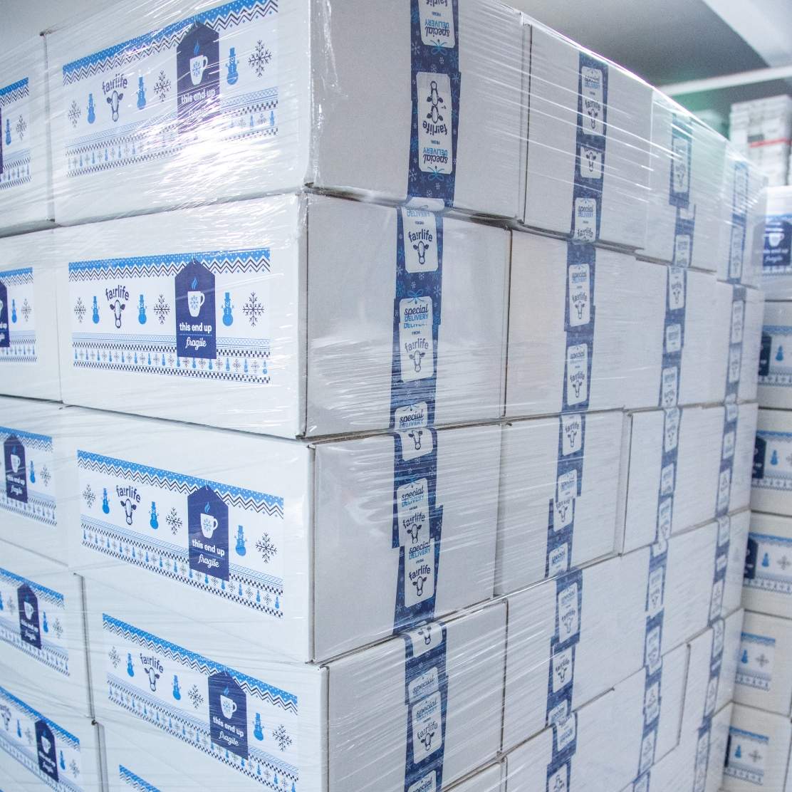 An extreme angled shot of plastic wrapped pallets of stacked and sealed mailing boxes.